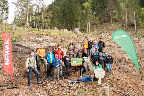 PENNY Verkaufsleiter Patrik Opressnig, Waldquelle Marketingleiterin Dagmar Habeler, Klassenlehrer und Förster Christian Dullnig pflanzen mit den Schüler:innen neue Bäume in Winklern.